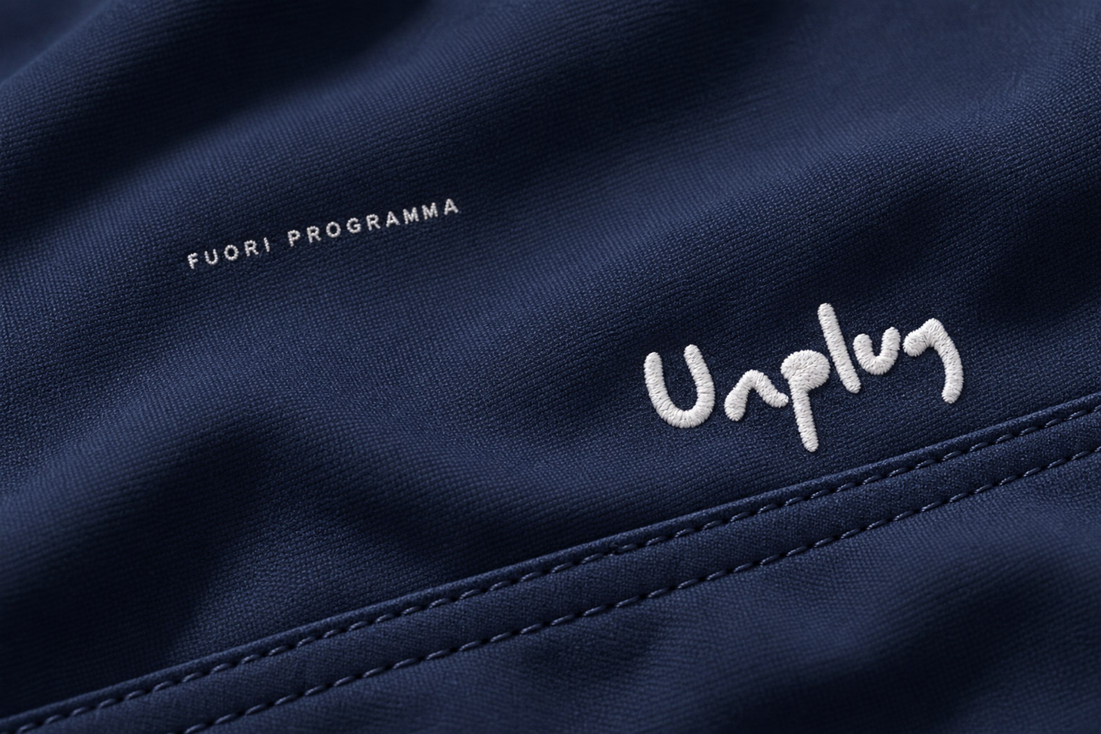Dettaglio di tessuto estivo con logo Unplug.